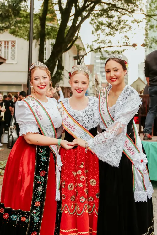 IMAGEM DA FESTITÁLIA COM TRÊS MULHERES VESTIDAS CONFORME CULTURA DA ÉPOCA